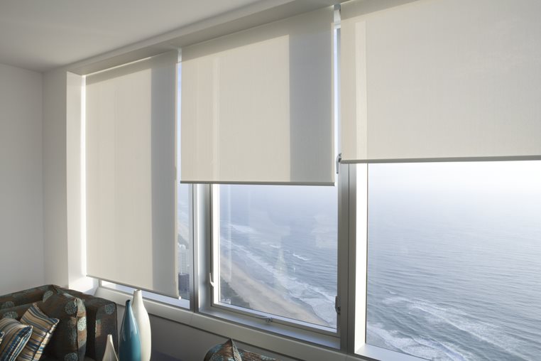 Sheer roller blinds softening the sun over an ocean view in a Gold Coast apartment